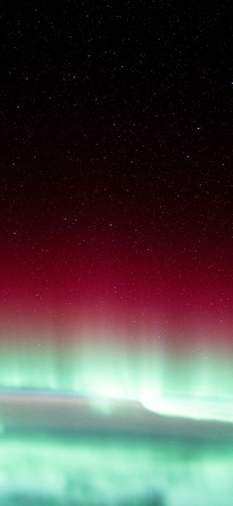 A red and green aurora borealis above Canada's Gulf of St. Lawrence