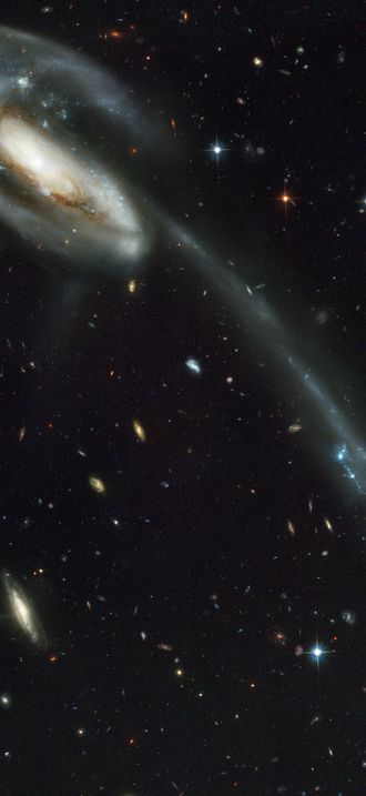 A 'wallpaper' of distant galaxies is a stunning backdrop for a runaway galaxy