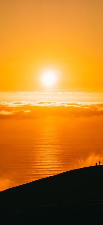 Orange sunrise and mountain silhouette (Unsplash)