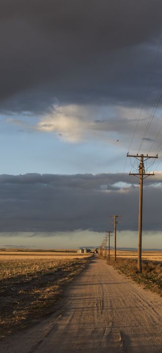 Dusk approaches along a dusty road in Sedgwick County, near Julesburg, Colorado