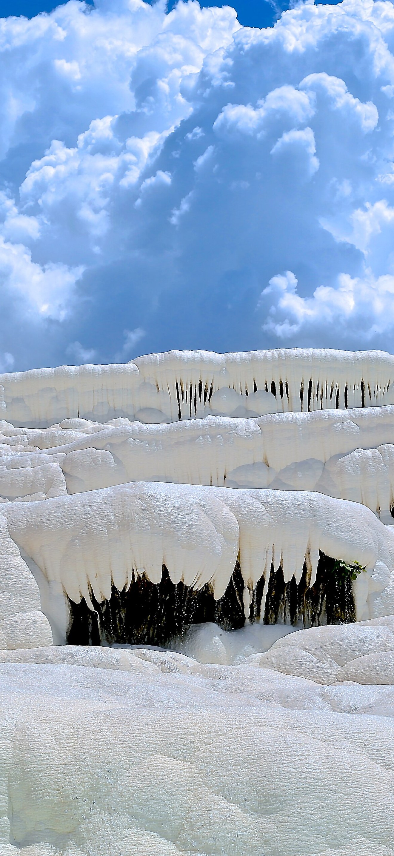 Frozen snow touching a blue cloudy sky